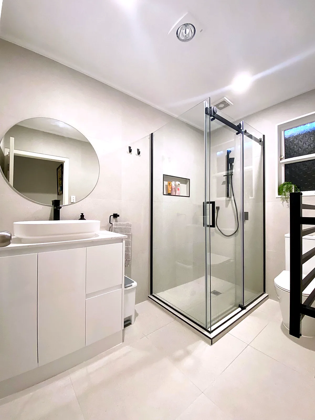 Bright bathroom renovation with frameless corner shower — Glenbrook, Auckland